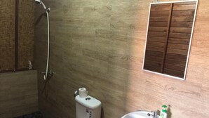 Un baño con inodoro, bidé y lavamanos.