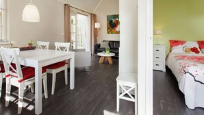 A cozy room with a dining area, a sofa, a bed, and a painting on the wall. - Holiday Home in Ravenstein With Garden (Overlangel)