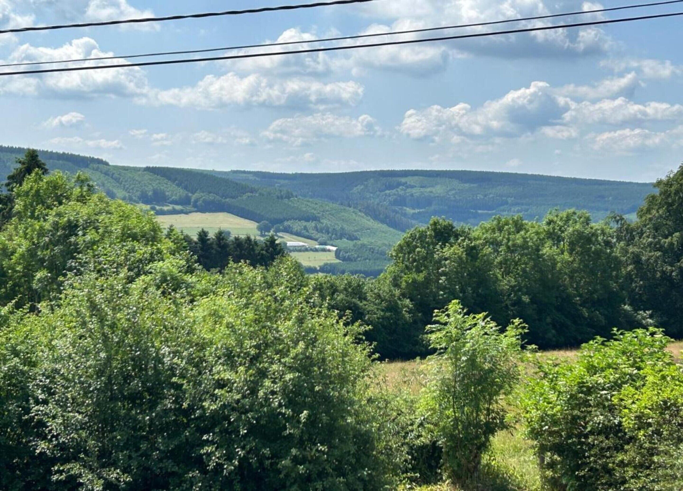 A lush green landscape with rolling hills and a clear sky.