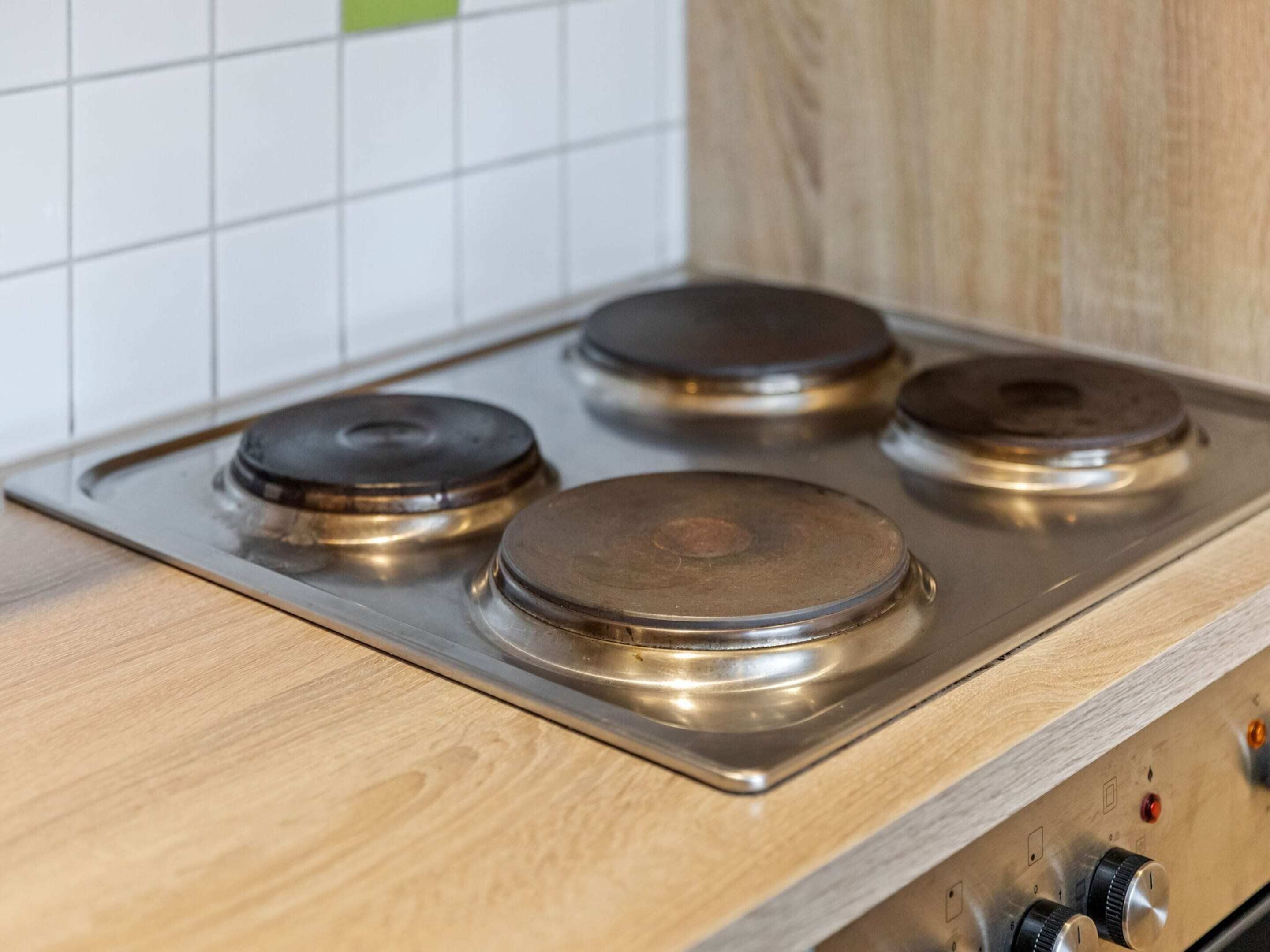 A kitchen with a stainless steel stove and wooden cabinets.