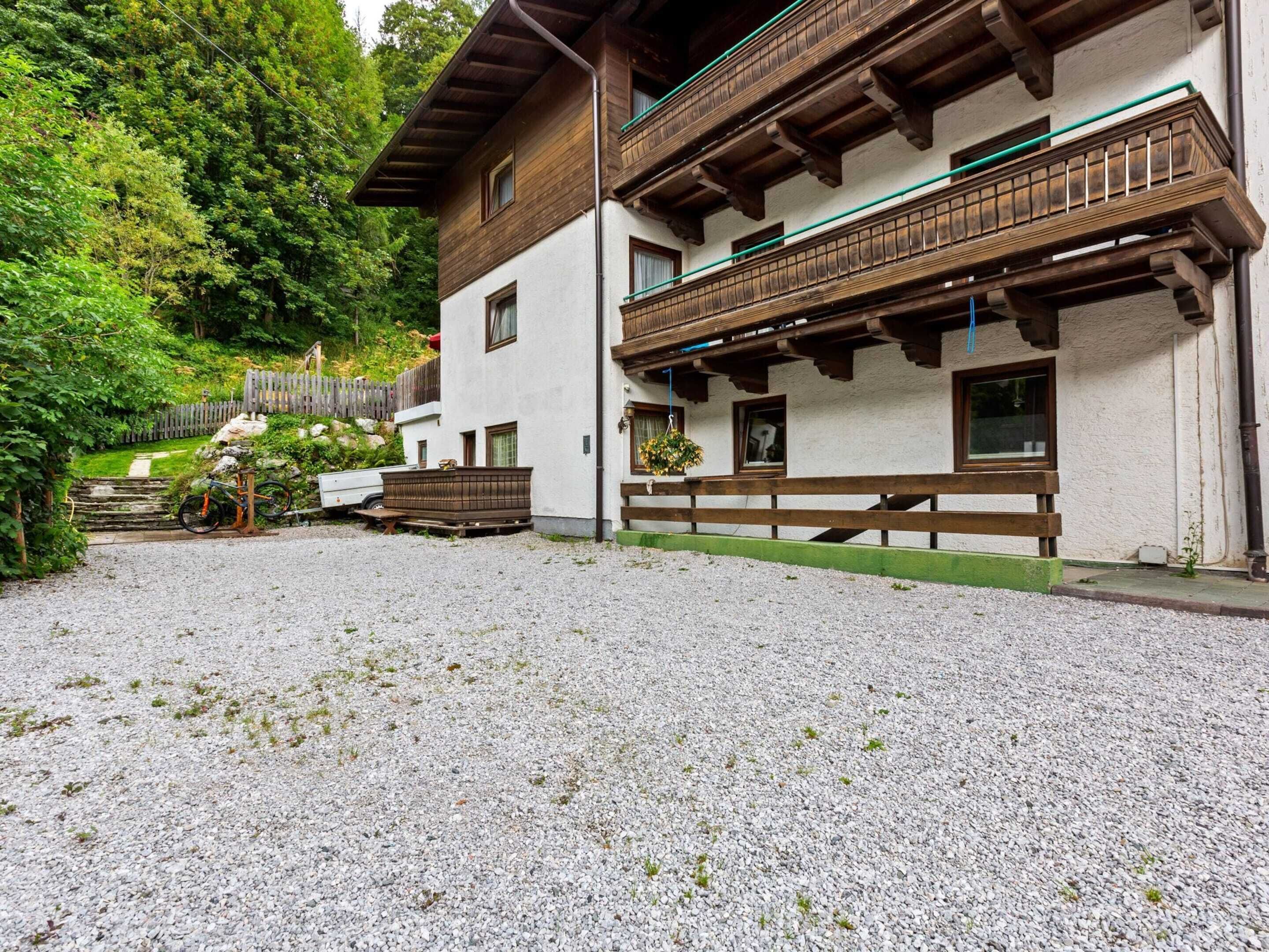 Ein traditionelles Chalet mit Kiesauffahrt, Holzbalkonen und Holzzaun.