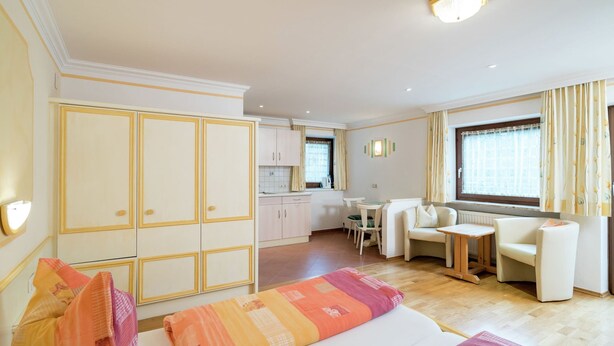 A hotel room with a bed, a sofa, a small dining table, and a kitchenette. - Spacious Apartment in Saalbach-hinterglemm near Ski Area (Saalbach-Hinterglemm)