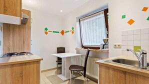 A compact kitchen with a stove, a small dining table, and a chair. - Spacious Apartment in Saalbach-hinterglemm near Ski Area (Saalbach-Hinterglemm)