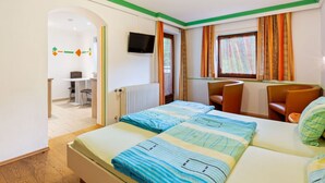 A hotel room with two beds, a desk, a chair, a television, and a window with curtains. - Spacious Apartment in Saalbach-hinterglemm near Ski Area (Saalbach-Hinterglemm)