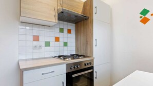A kitchen with a gas stove, oven, and white cabinets. - Spacious Apartment in Saalbach-hinterglemm near Ski Area (Saalbach-Hinterglemm)