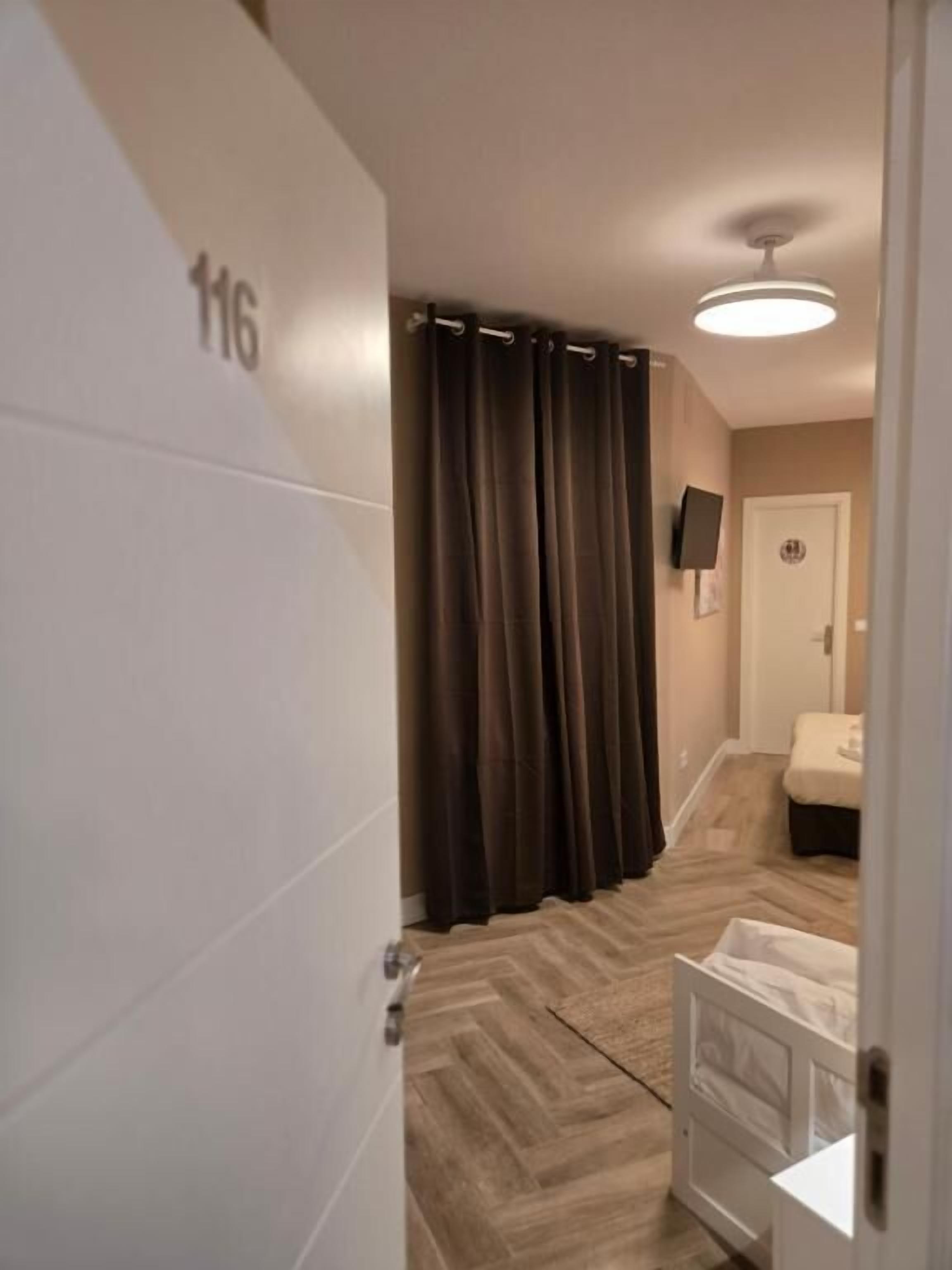 Una habitación de hotel con una cama, un baño y una puerta con el número 116.