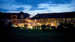 A large, multi-story building with a central courtyard, surrounded by smaller structures. - Hotel Restaurant Les Bergeronnettes (Champagneux)
