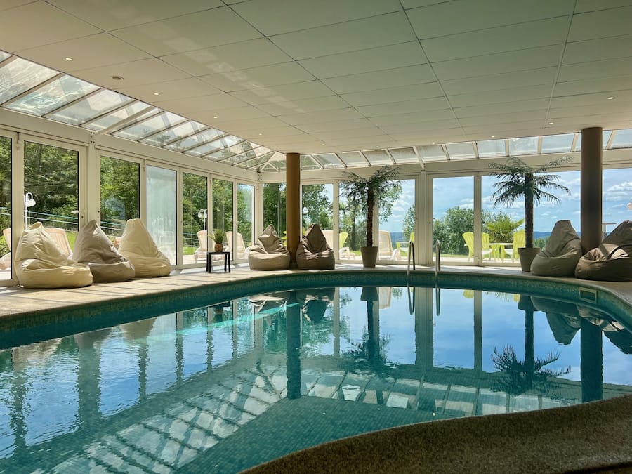 Una piscina techada, sillones reclinables de piscina