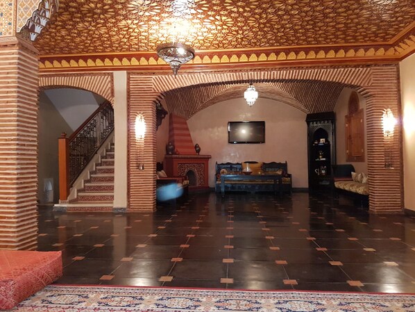A spacious interior with a grand staircase, a patterned carpet, and a traditional sofa. - Rental Villa Amerchich (Marrakech)