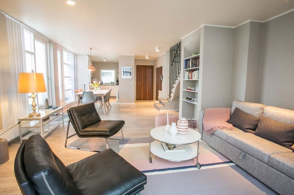 A modern living room with a sofa, a coffee table, and a bookshelf.