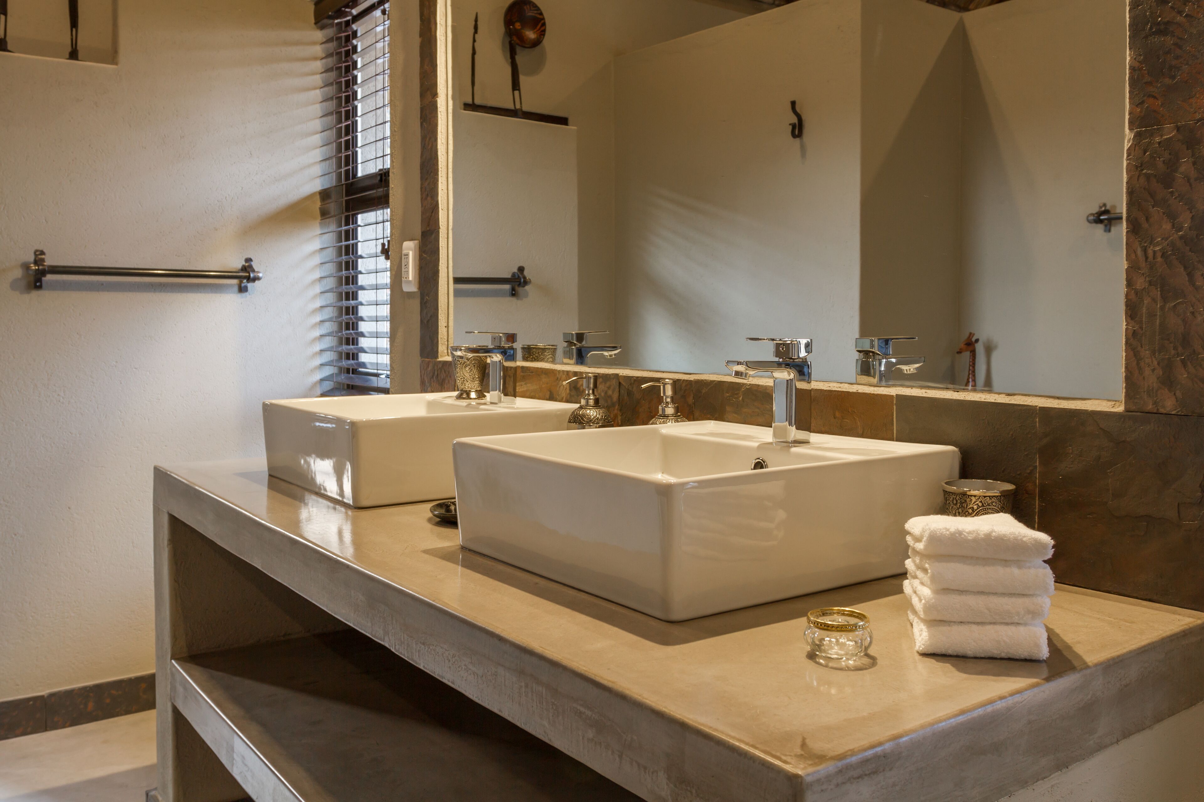 A bathroom with two sinks, a large mirror, and a towel rack.