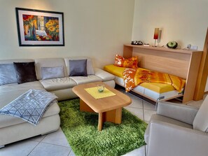 Un salon moderne avec un canapé, une table basse et une petite table d’appoint.
