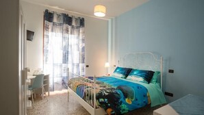 A bedroom with a bed, a desk, and a chair.