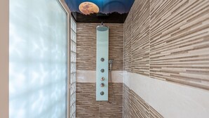 A modern bathroom with a wooden panel design, a shower with multiple controls, and a ceiling mural of a moon. - Castell des Paradís - Family villa near the sea (Portopetro)