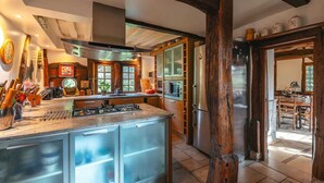 Una cocina moderna con una isla central, electrodomésticos integrados y vigas de madera rústicas.