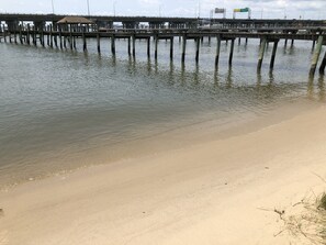 A beach with a wooden pier extending into calm waters. - Harbor Delight On The Bay - Private Sandy Beach! 4 Bedroom Home by RedAwning (Norfolk)