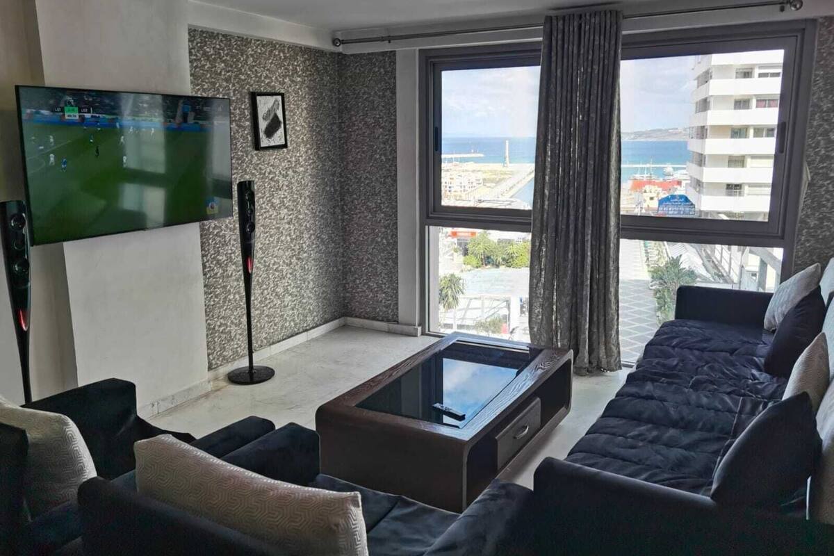 A modern living room with a flat-screen TV, a coffee table, and a sofa.