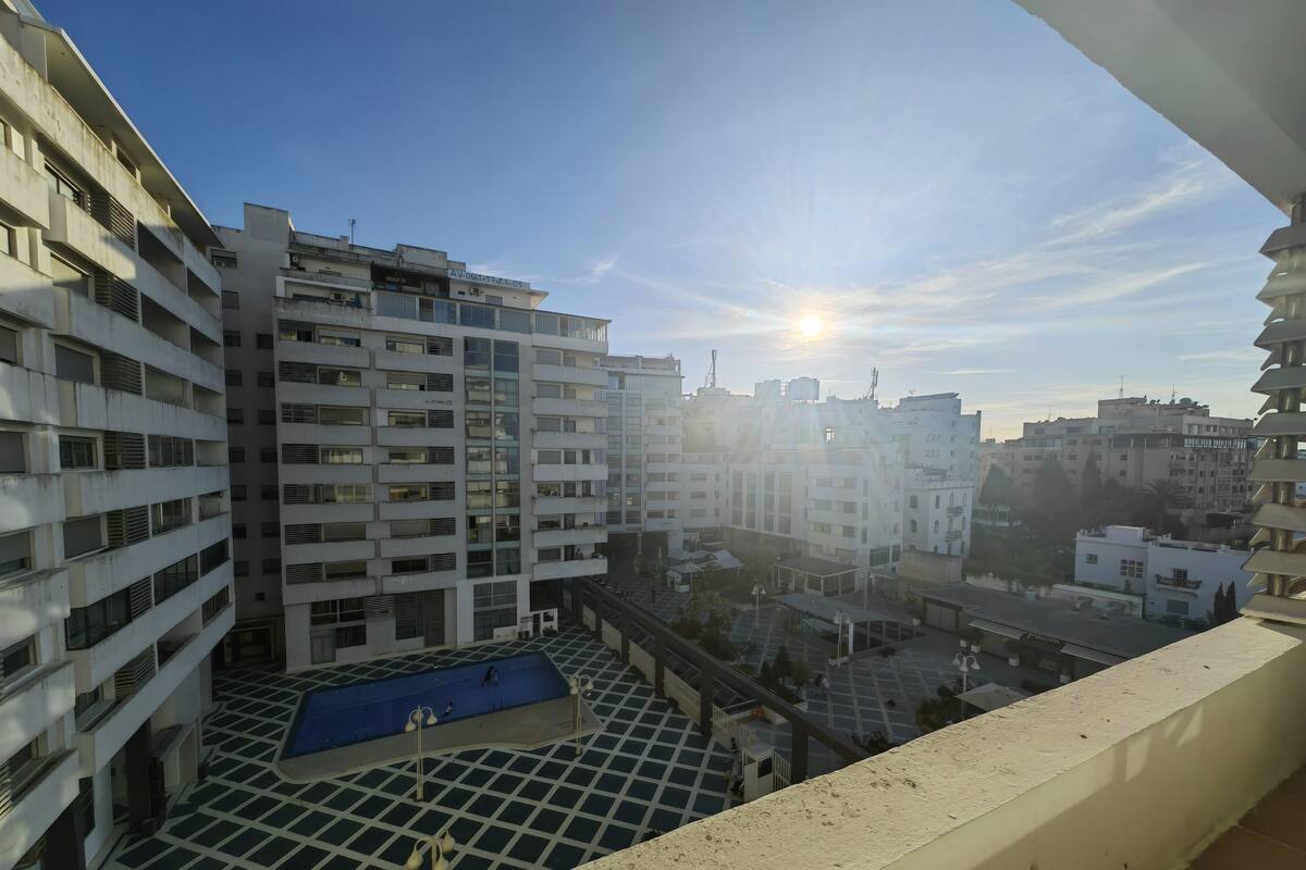 A view of a multi-story residential building with a rooftop pool area.