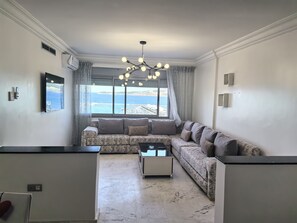 全景公寓 | 客厅 | 55-英寸智能电视(配备卫星频道)、电视、首映电影