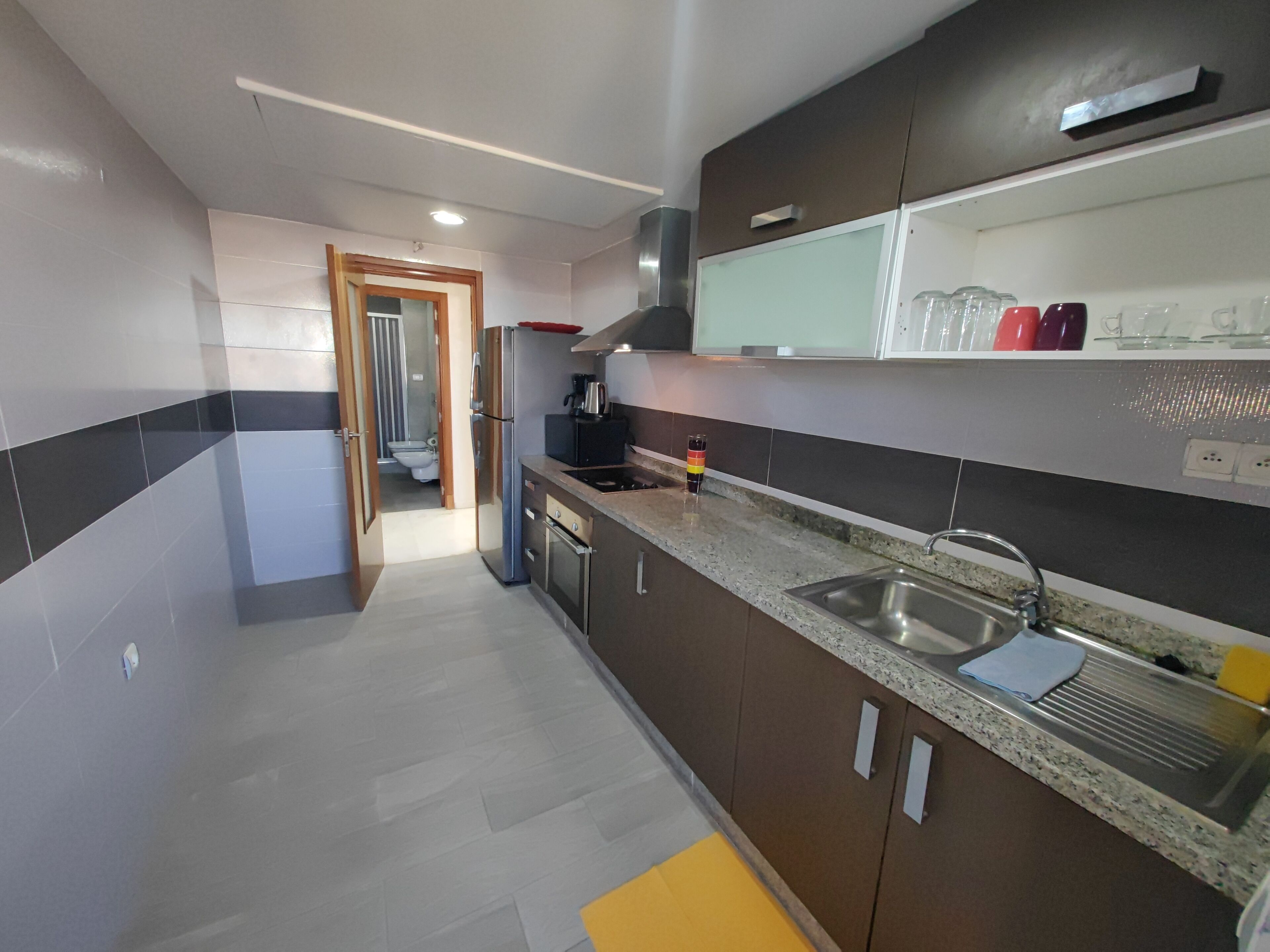 A modern kitchen with stainless steel appliances, a granite countertop, and a built-in oven.