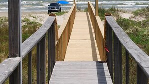 A wooden boardwalk leading to the beach with a car parked nearby. - Golden Surfside--It has GOLDEN VIEWS and it's brand new!! (Surfside Beach)