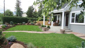 Un jardin bien entretenu, avec une pelouse, des allées et des rochers décoratifs.