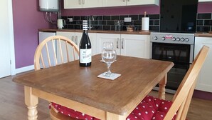 A kitchen with white cabinets, a gas stove, and a wine bottle on the table. - Swallows Nest, Cottage, Fishing Lakes Nr Cleethorpes, Adults Only Pet Friendly  (Lincolnshire)