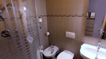 Ein Badezimmer mit Duschkabine, Toilette und Waschbecken.