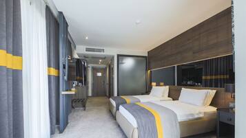 Ein modernes Hotelzimmer mit zwei Betten, einem großen Spiegel und einer Wand mit Holzpaneelen.