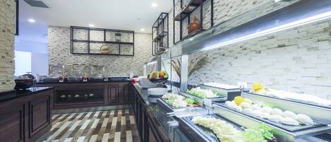A buffet area with various food items, a brick wall, and a patterned floor.