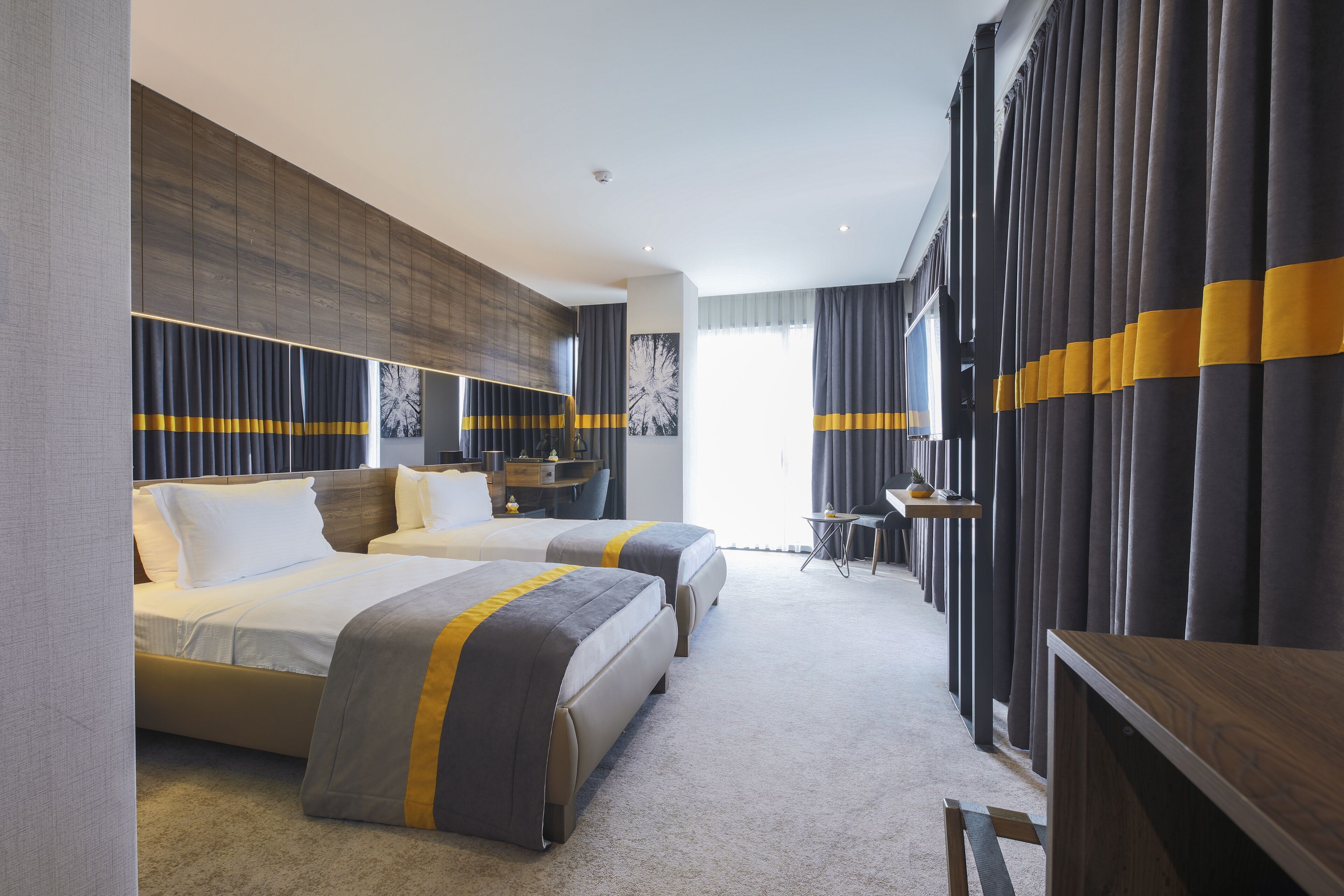 Une chambre d’hôtel avec deux lits, un bureau et une chaise.