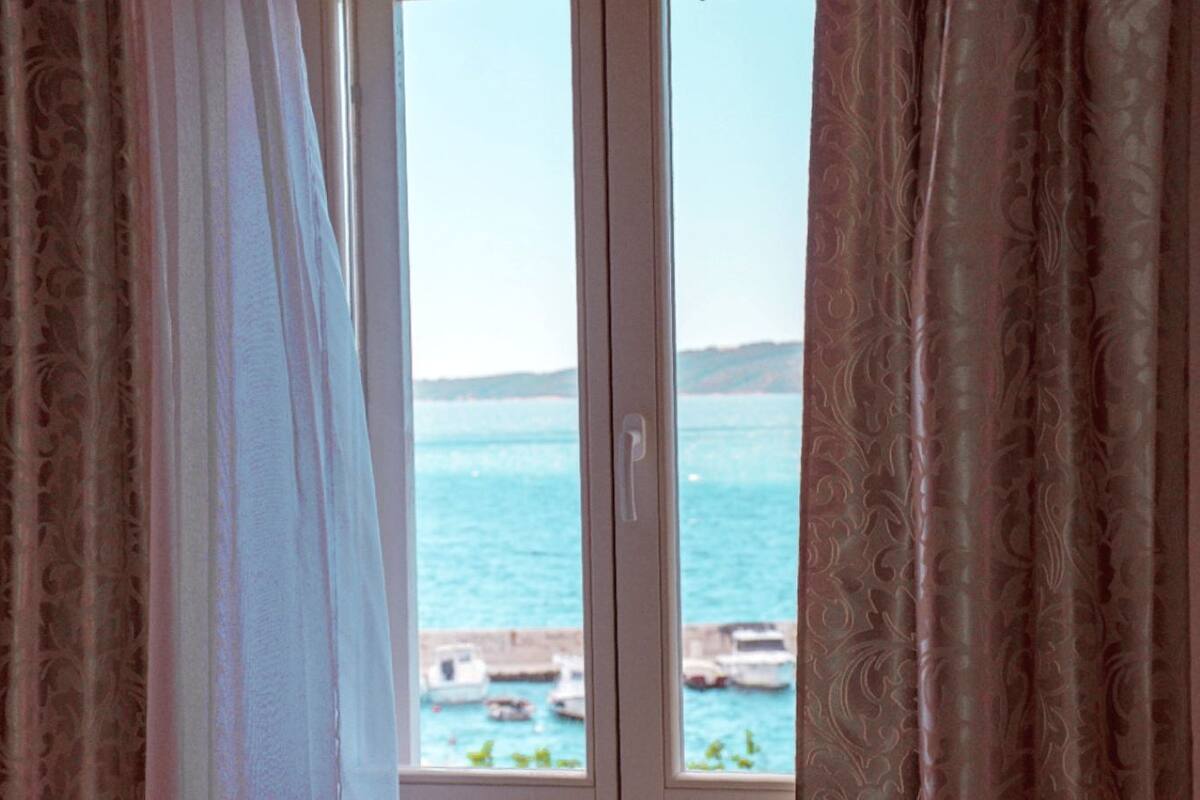 Una ventana con vista al mar y barcos.