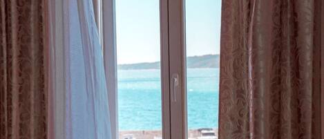 Una ventana con vista al mar y barcos.