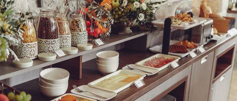 A buffet setup with various food items and condiments.