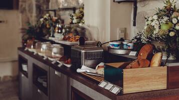 A buffet setup with various food items and a decorative floral arrangement.