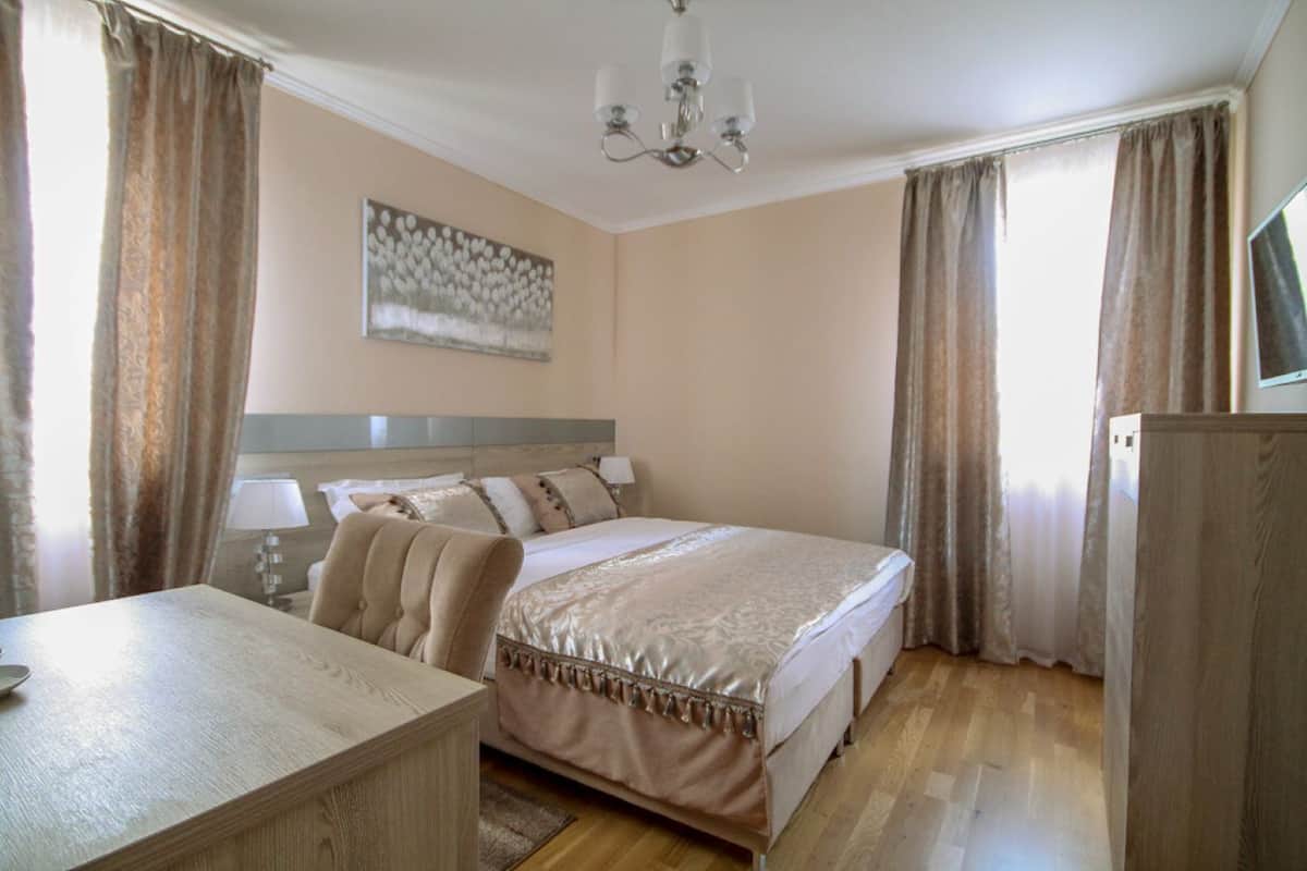 Un dormitorio con cama, escritorio, silla, lámpara y candelabro.