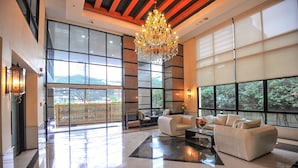 A spacious lobby with a chandelier, large windows, and a seating area. - 42 Grand Residence (Bangkok)