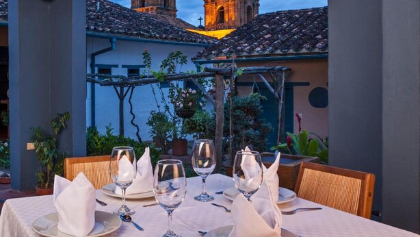 Une table dressée pour le dîner, avec en arrière-plan une vue sur des bâtiments historiques.