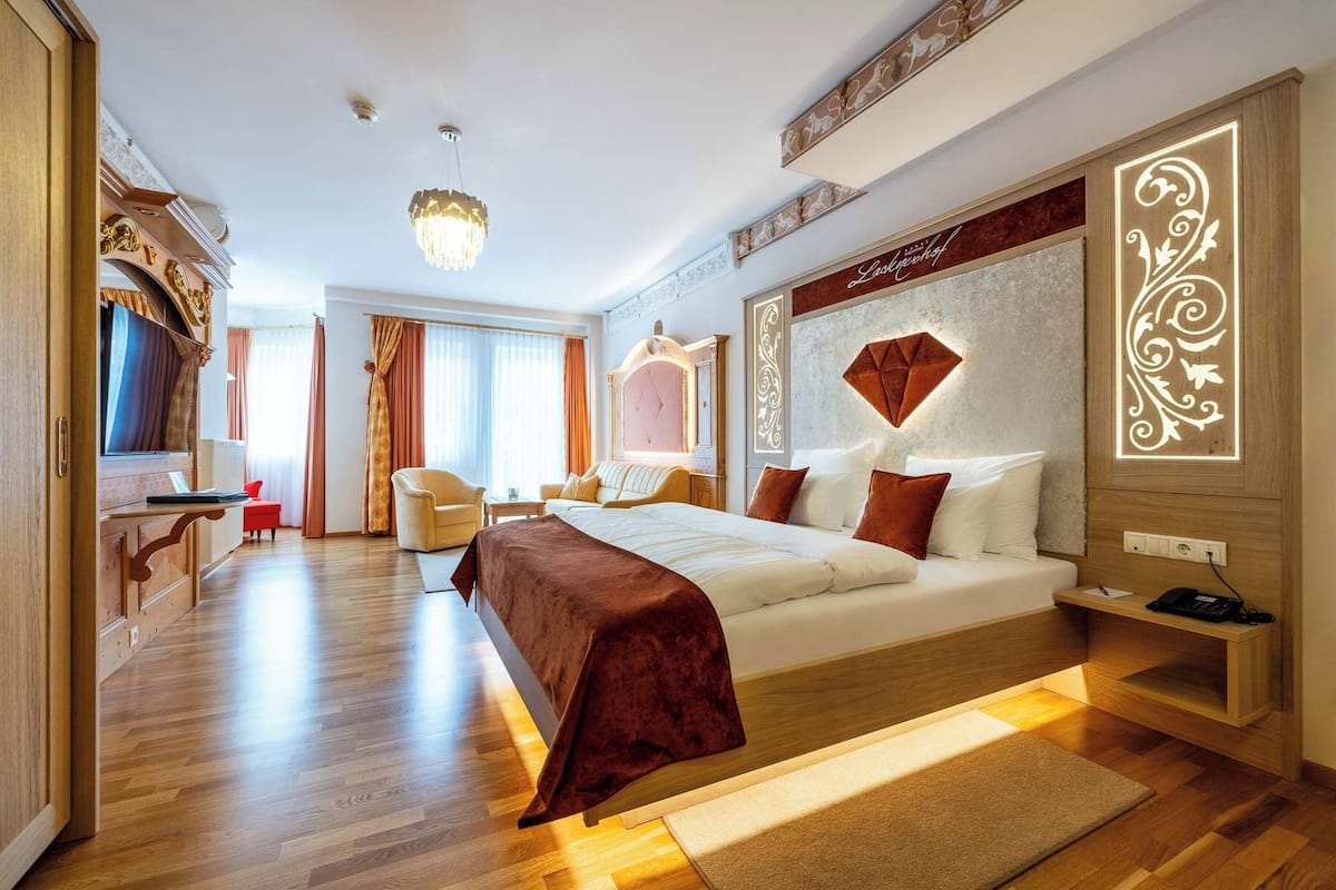 Une chambre d’hôtel spacieuse, dotée d’un grand lit, d’un bureau et d’un coin salon.