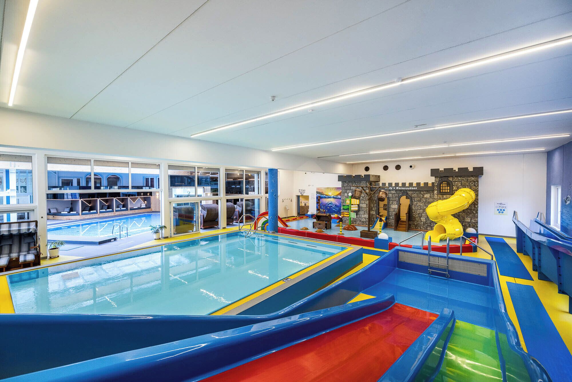 Une piscine intérieure dotée de toboggans et d’aires de jeux.
