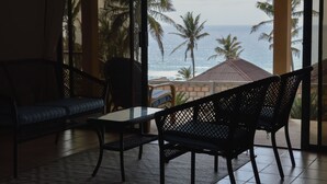 Une pièce avec vue sur l’océan, comprenant un canapé, un fauteuil et une table.
