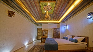 A bedroom with a wooden bed, a patterned rug, and a decorative ceiling.