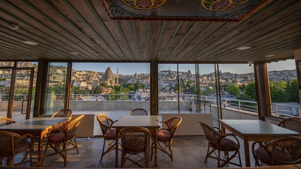 A terrace with wicker furniture and a view of a cityscape.