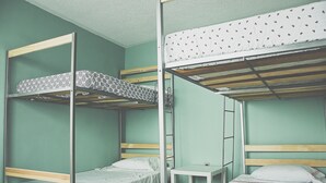 Un dormitorio con literas, una mesita pequeña y una escalera.