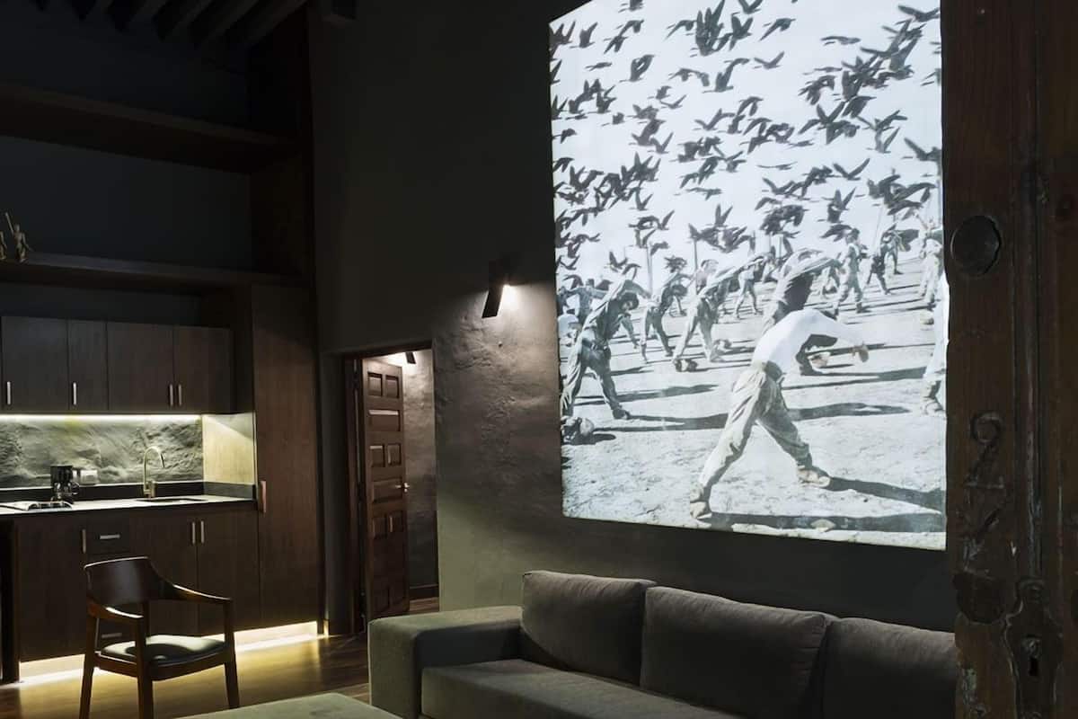 A modern living room with a large wall-mounted television displaying a historical scene.