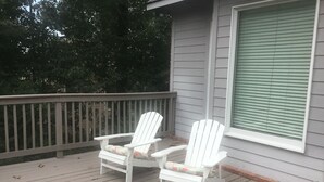 A wooden deck with two white Adirondack chairs and a window with blinds. - Beautiful Home close to campus (Oxford)