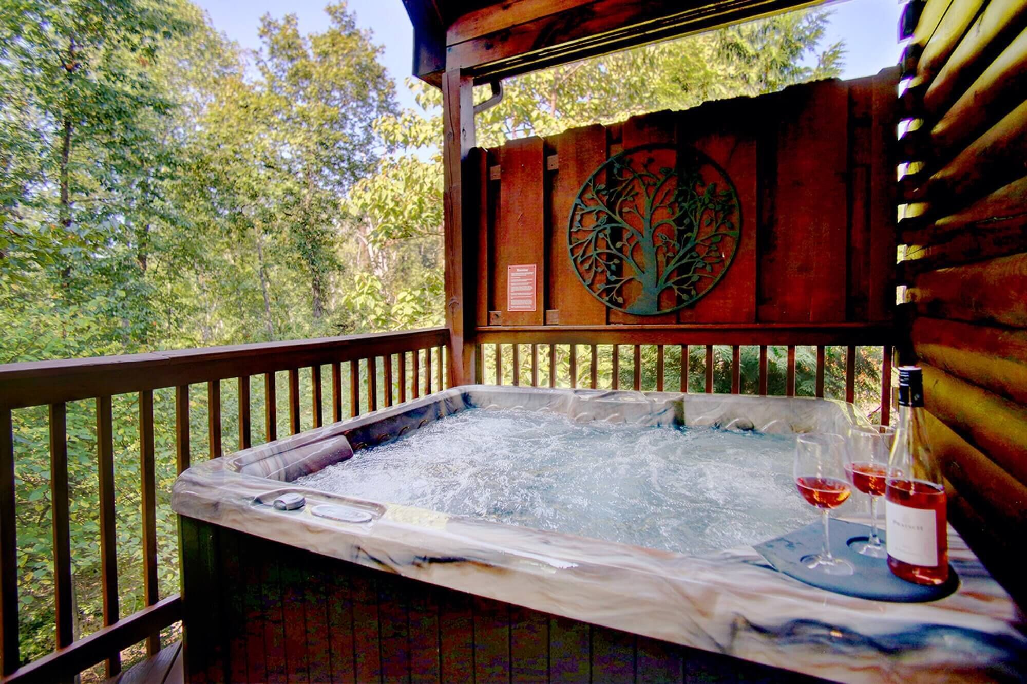 A hot tub with a wooden deck, surrounded by trees.