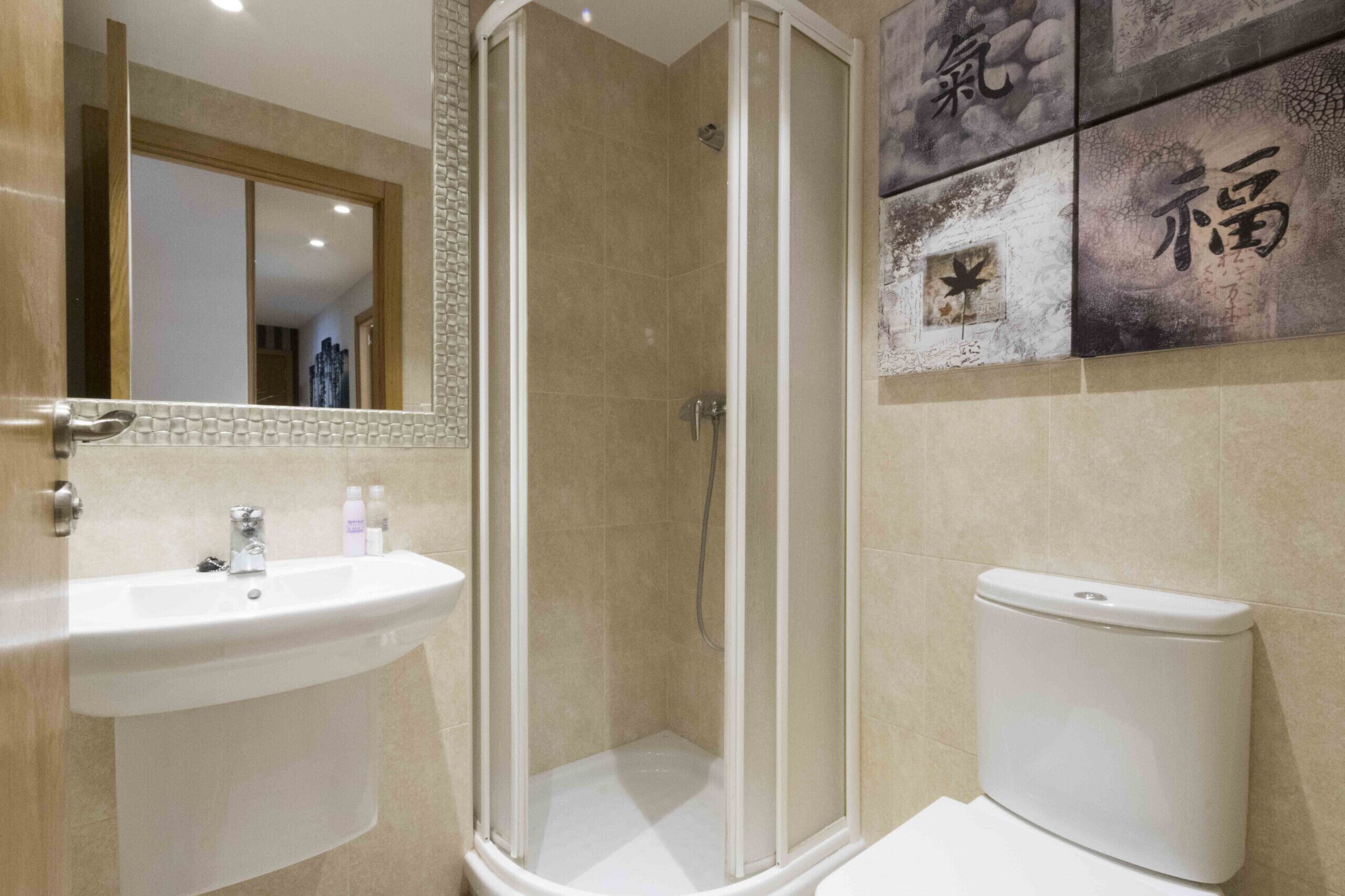 Un baño con cabina de ducha, lavabo e inodoro.