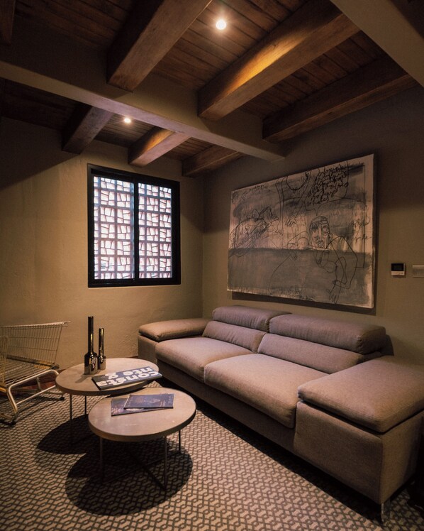 A cozy living room with a sofa, a coffee table, and a large abstract painting on the wall. - Morada La Noria (Puebla)
