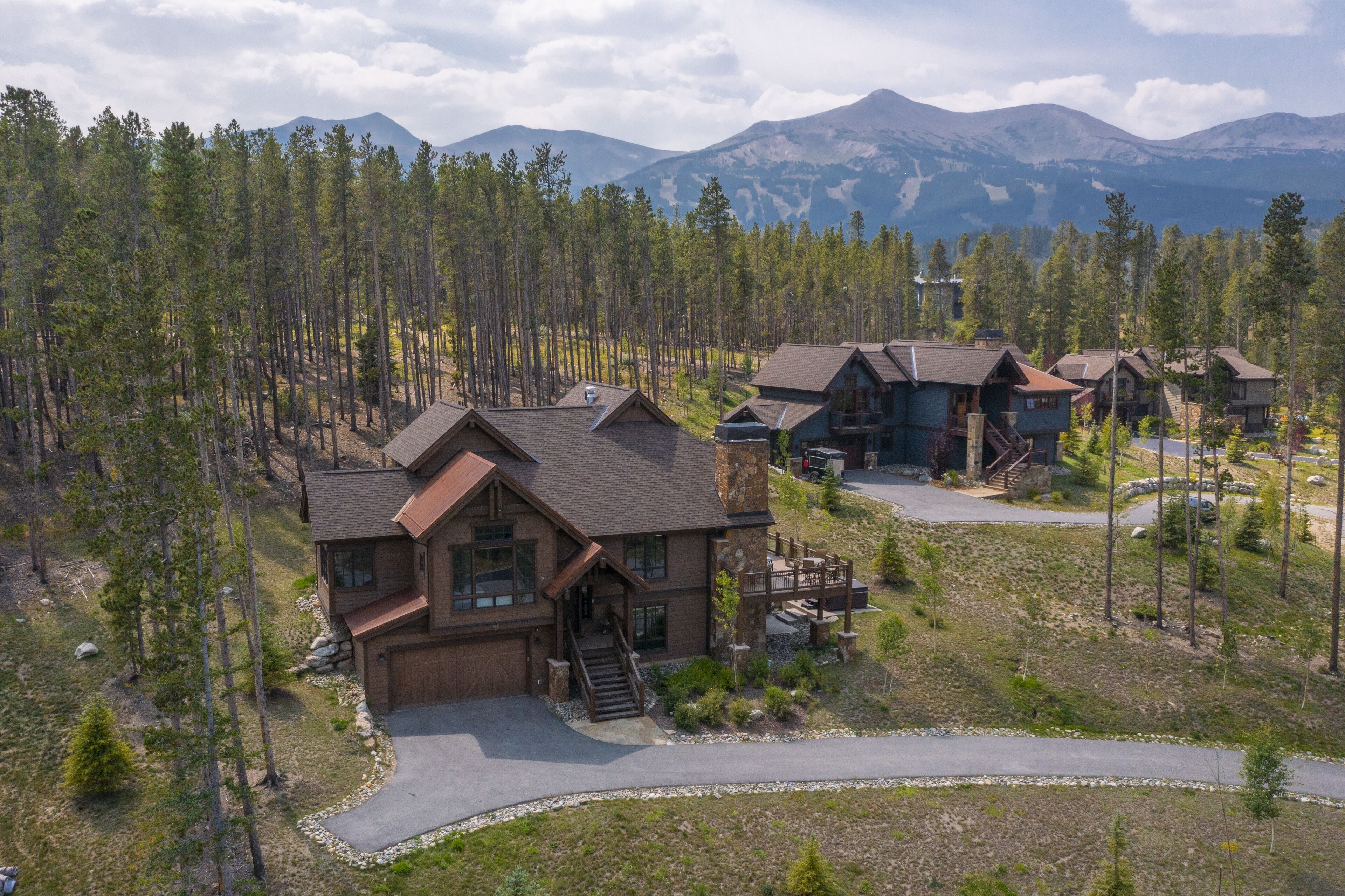 A lodge with multiple cabins, a central building with a staircase, and a surrounding forest.